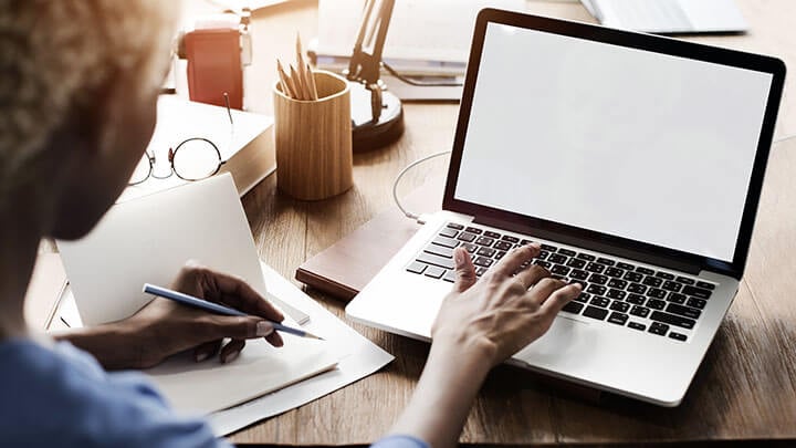 een vrouw die op een laptop zit te typen