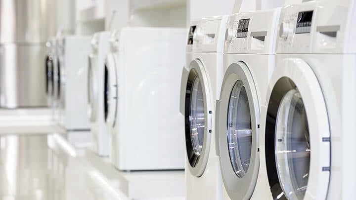 3 witte wasmachines staan aan de rechterkant op een rij
